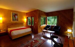 Banon Resorts في مانالي: غرفة نوم بسرير وطاولة وكراسي