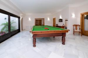 a pool table in a living room with a pool at El palacete in Estepona