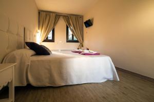 - une chambre avec un grand lit blanc et une fenêtre dans l'établissement El palacete, à Estepona