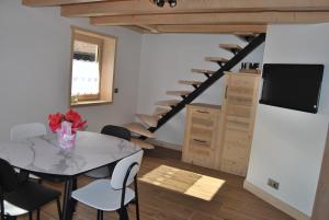 a living room with a table and a staircase at La ferme du Mont-Blanc in Combloux