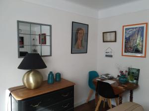 Zimmer mit einem Schreibtisch und einer Lampe auf einer Kommode in der Unterkunft gîte St Pierre in Melle