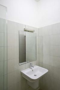 a white bathroom with a sink and a mirror at Milestone City - Appartements à louer in Antananarivo