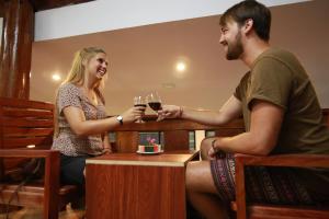 un homme et une femme tenant des verres de vin dans l'établissement Garden Resort, à Vang Vieng