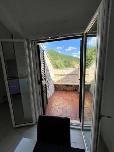 Zimmer mit Glasschiebetür und Blick auf einen Balkon. in der Unterkunft Blackheart casa vacanze in Pellezzano