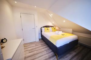 a bedroom with a large bed with yellow pillows at Pluxa Lemon Quartz - Wi-Fi, Workspace, Parking, in Sutton in Sutton