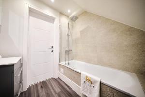 a bathroom with a shower and a tub and a sink at Pluxa Lemon Quartz - Wi-Fi, Workspace, Parking, in Sutton in Sutton