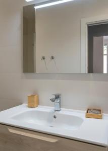 a white bathroom sink with a large mirror at Basetxea apartment by People Rentals in Basauri