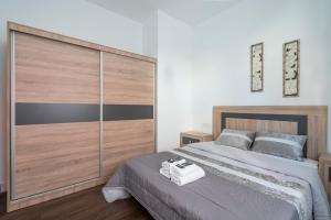 een slaapkamer met een groot bed en een grote houten kast bij Basetxea apartment by People Rentals in Basauri +17 foto's
