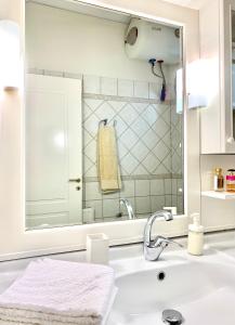 een witte badkamer met een wastafel en een spiegel bij Aggelos and Thisbe Chania Suburbs Sea View Guest House in Chania