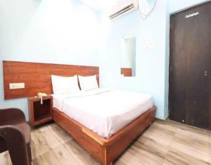 哈里瓦的住宿－The Mangal Inn by StayApart，一间卧室配有一张带木制床头板的床