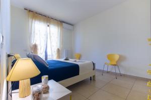 a bedroom with a bed and a table with a lamp at Appartamento Galileo Deluxe - MyHo Casa in Tortoreto Lido
