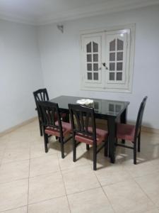 a dining room with a black table and chairs at الفرعون المصري in `Ezbet Bûgti