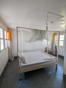 a bed with a canopy in a room at Karibu Homestay Moshi in Moshi