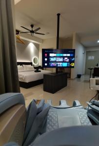 uma sala de estar com uma cama e uma televisão de ecrã grande em Luxury Couple Suites l Free Netflix l Mini Cinema l Massage Chair l Bathtub l WIFI 200mbps l Town Area Bali Residence em Malaca