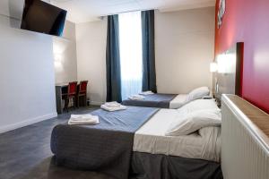 a hotel room with two beds and a flat screen tv at Hotel Du Dauphiné in Lyon