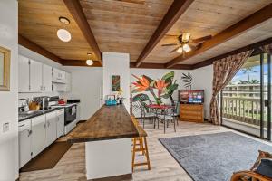 a kitchen with white cabinets and a wooden ceiling at Newly Upgraded 1BR Unit Near Beach max of 5 Guests in Kailua-Kona