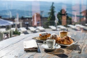 einen Tisch mit 2 Tellern Gebäck und einer Tasse Kaffee in der Unterkunft Ai Tardì in Diano dʼAlba
