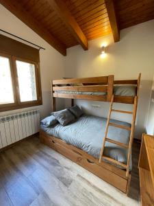 1 dormitorio con 2 literas y escalera en Casa de les Escoles, Espinalbet - ALBERGA, en Castellar del Riu