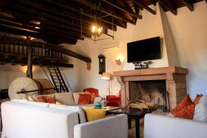 sala de estar con sofá y chimenea en Cortijo Rural Alcornocosas, en Córdoba