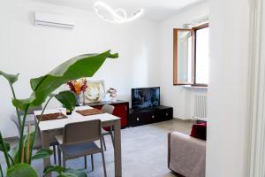 a living room with a white table and a plant at Appartamento il Melograno in Rapolano Terme