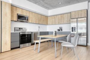 a kitchen with stainless steel appliances and a table and chairs at Downtown 1BR w Pool Gym WD nr Staples Center LAX-545 in Los Angeles