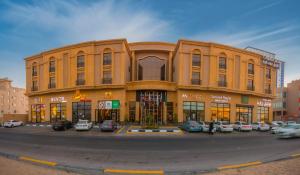 a large building with cars parked in front of it at The Address Palace Apartments in Dammam