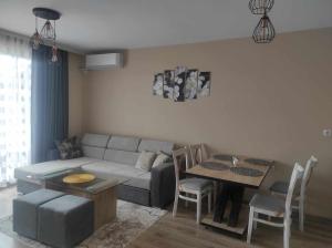 a living room with a couch and a table at Апартамент Четири сезона 2 in Velingrad