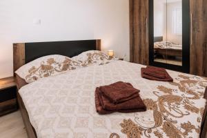 uma cama com duas toalhas num quarto em Sunrise Apartments em Senec