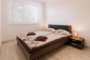 a bedroom with a bed with two towels on it at Sunrise Apartments in Senec