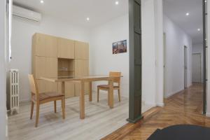 uma sala de jantar com uma mesa de madeira e cadeiras em Sol Apartment Deluxe-Nuñ-Arce em Madrid