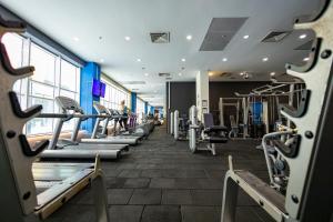 a gym with rows of treadmills and machines at 18th & 16h Floor Secure Luxury Condos With Pool & Fitness Included In Price in Skopje