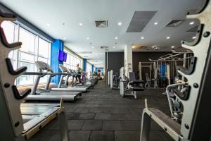 a gym with rows of treadmills and machines at 18th Floor Secure Luxury Condo With Pool & Fitness Included In Price in Skopje