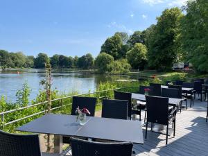 un patio con mesas y sillas junto a un río en Hotel Excellent, en Lübeck