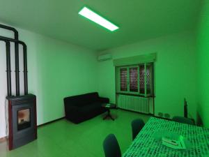 a green room with a fireplace and a table and chairs at Casa Zoe in Piacenza +6 photos
