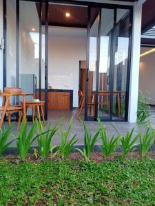 een patio met een tafel, stoelen en planten bij Semanggi Private Villa in Ubud