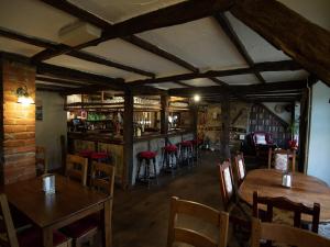 a restaurant with wooden tables and chairs and a bar at The Heath Inn in Leighton Buzzard