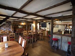um restaurante com mesas e cadeiras de madeira e um bar em The Heath Inn em Leighton Buzzard
