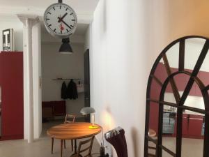 a clock hanging on a wall next to a table at Design Loft in ehemaliger Spinnerei in Mels