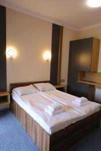 sypialnia z dużym łóżkiem z ręcznikami w obiekcie RIVER SIDE w mieście Polyana (Polana)