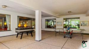 a living room with a piano and a table at HOTIDAY Residence San Martino in San Martino di Castrozza