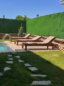 dwie ławki w trawie obok basenu w obiekcie Villa Mila w mieście Kartepe
