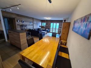 een eetkamer en een woonkamer met een houten tafel bij Greppons O 031 - MOUNTAIN apartment 10 pers in Veysonnaz