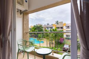 Habitación con balcón con vistas a la piscina. en Cosy 2BHK With WIFI From Anjuna Vagator, en Anjuna