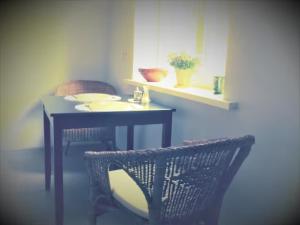 a table and chairs in a room with a table and a table and a chair at Cozy apartment near the airport in Rīga