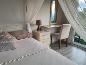 1 dormitorio con 1 cama, 1 silla y 1 ventana en Villa Mila, en Kartepe