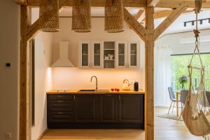 a kitchen with black cabinets and a sink at Teatralna1 in Piechowice