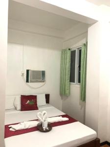 Habitación pequeña con cama y ventana en Axis Pension Hotel en Isla de Mactán