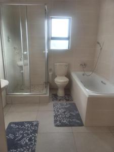 a bathroom with a toilet and a shower and a sink at Cottage on 14th in East London