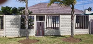 two palm trees in front of a house with gates at Cottage on 14th in East London