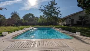 a swimming pool in a yard with a wooden deck at Maison spacieuse - Piscine - Jardin 